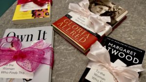 Womens History Month photo of books with pink ribbons